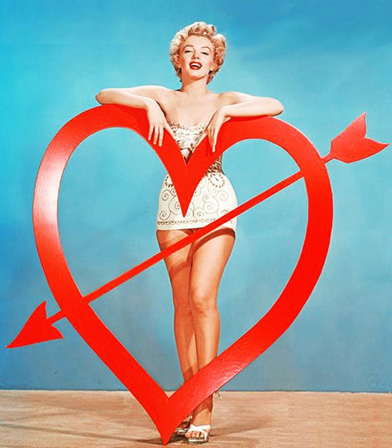 Marilyn Monroe poses with a large Valentine heart. 